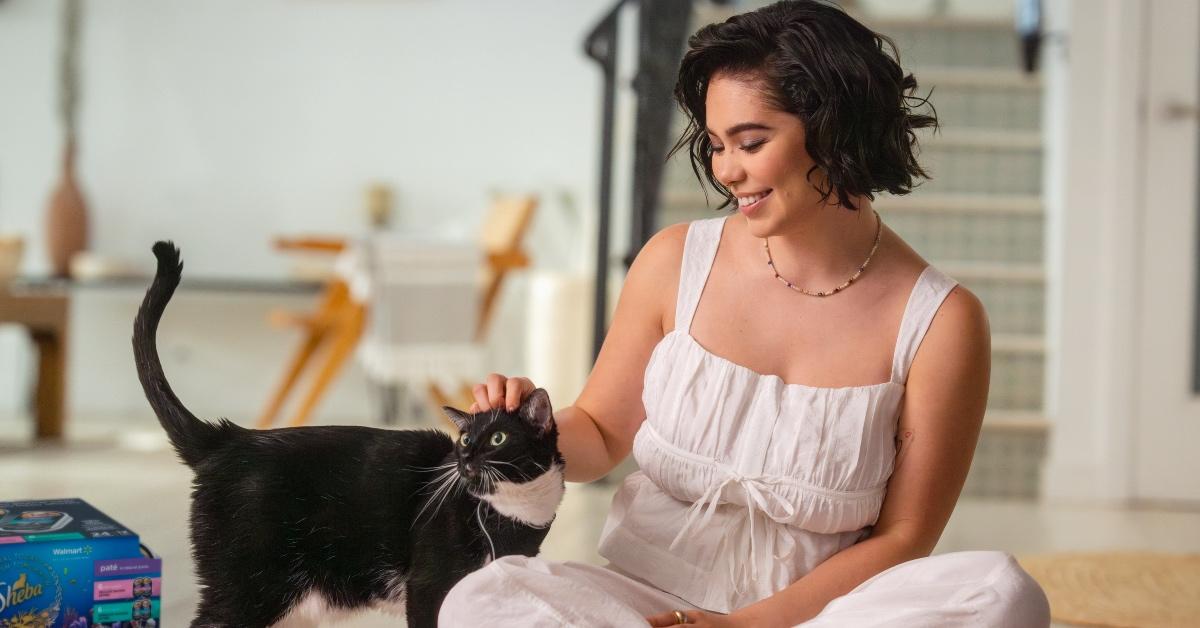 Auli'i Cravalho and her cat, Rocco, sitting in the kitchen 