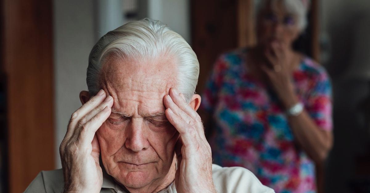 Elderly man clutching his head