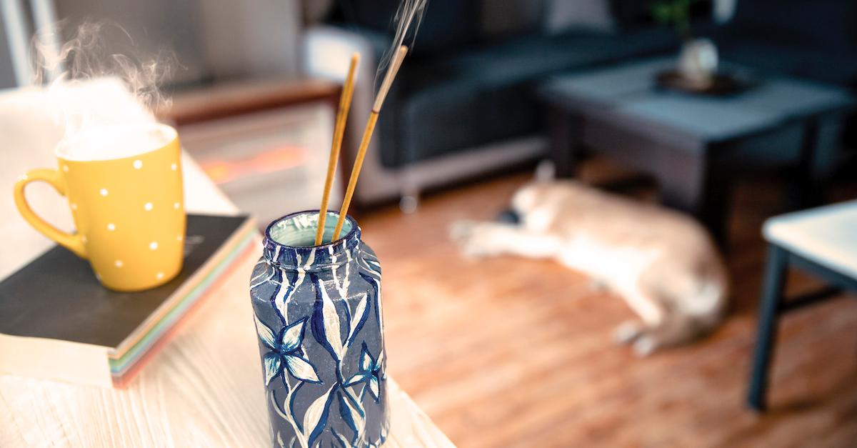 Incense burning next to a mug of tea.