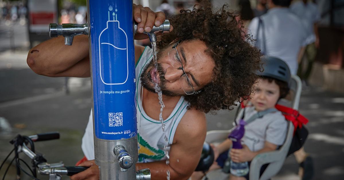 A man drinking water from a free drinking water fountain in paris