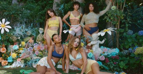 Five women in a field of flowers wearing lingerie