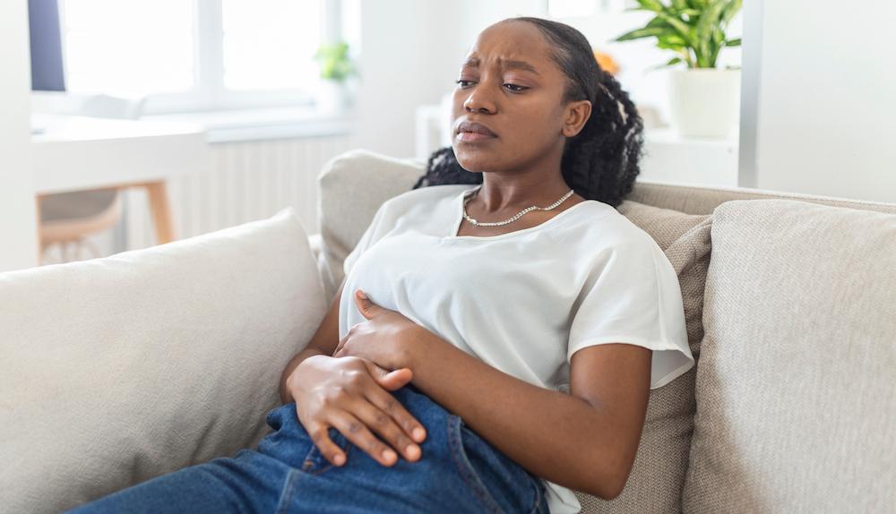 A woman holding her stomach in pain. 