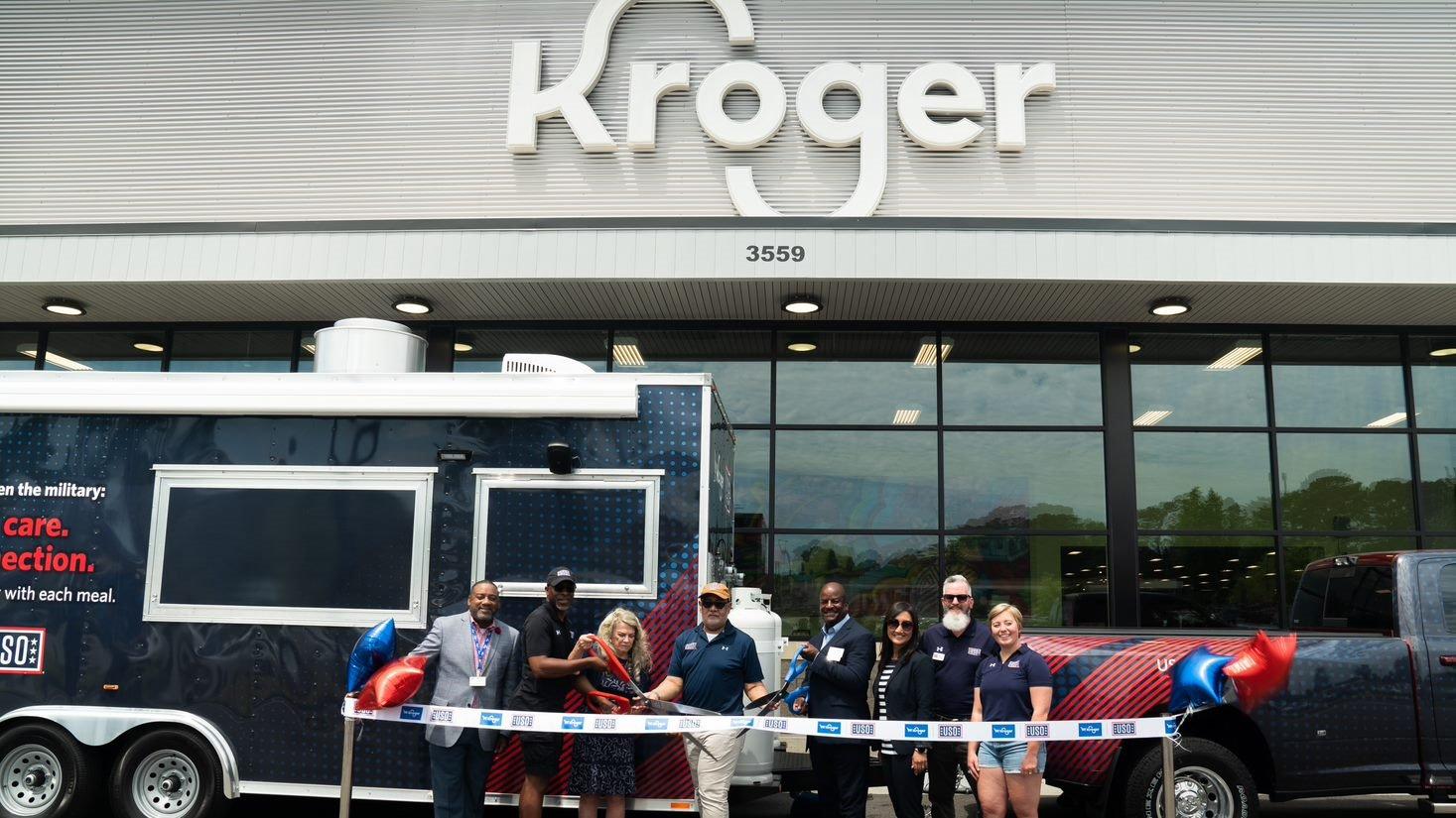 A ribbon cutting ceremony takes place in front of a Kroger store.