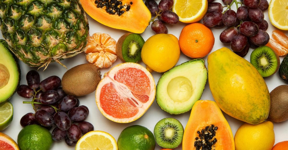 An array of fruit, including grapefruit, mango, kiwi, limes, and lemons