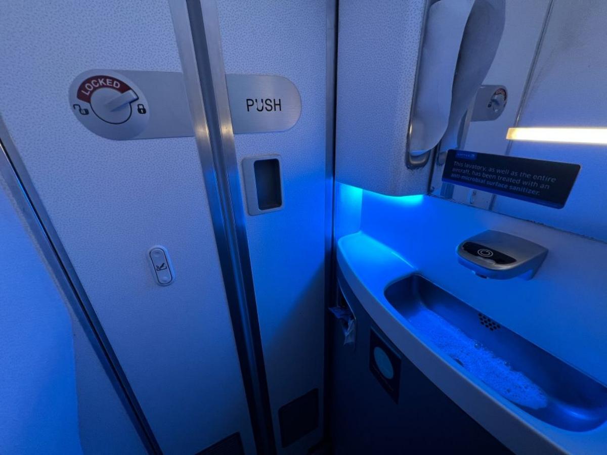 interior of airplane bathroom with blue lighting