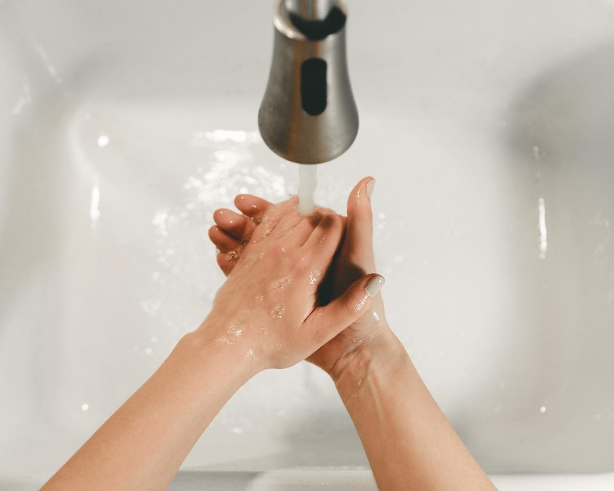 person washing hands under running water