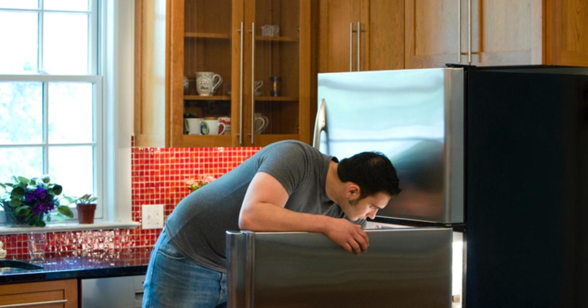 A photo of a man looking into the fridge
