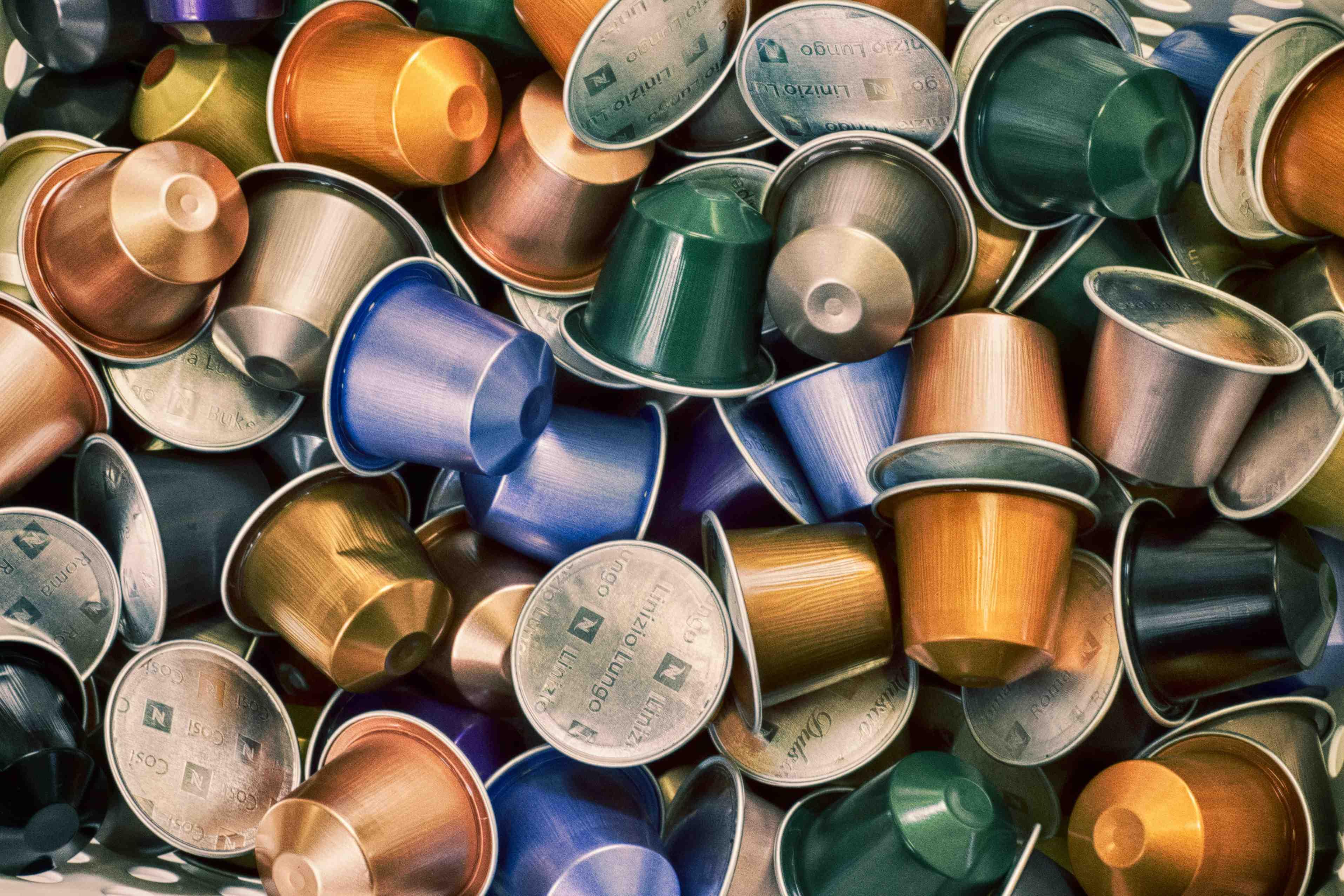 Many plastic coffee pods are stacked atop one another.