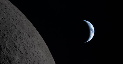 A sliver of the Earth is visable from behind the moon