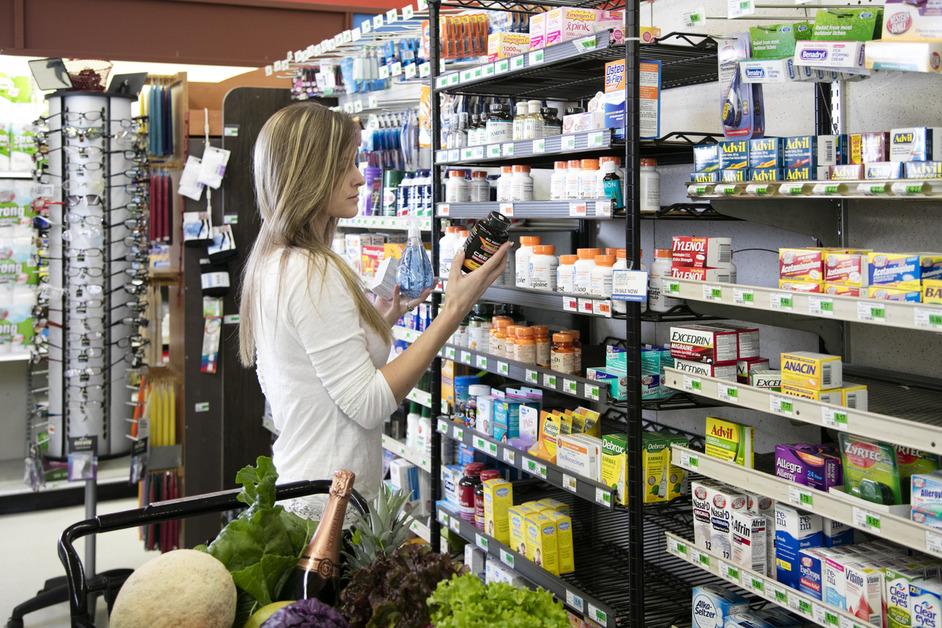 Woman shopping for supplements and health products in the store. 