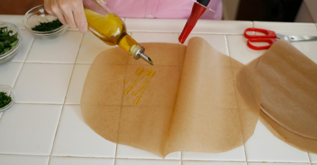 Woman applying cooking oil to parchment paper