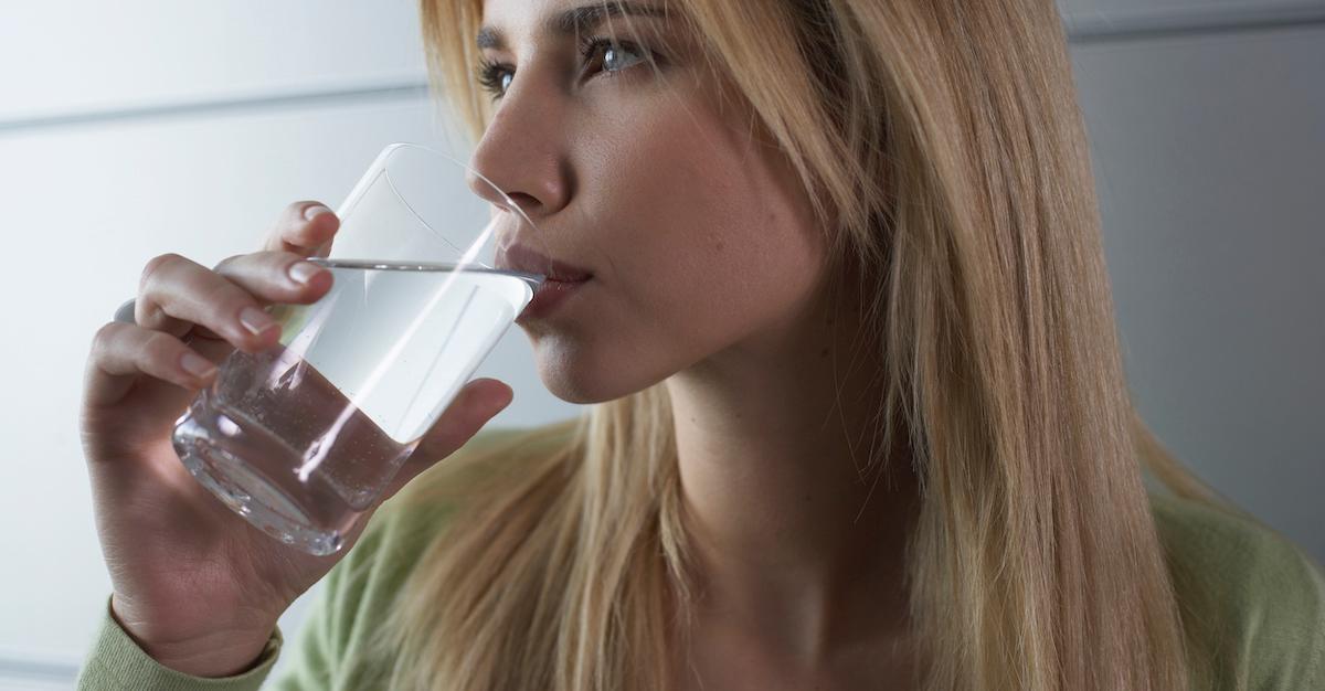 A woman drinking water from a glass