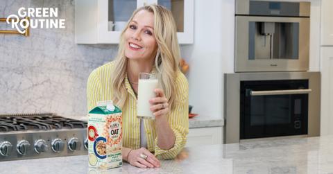 Photo of actor Jennie Garth holding a glass of Planet Oat plant-based milk in a kitchen