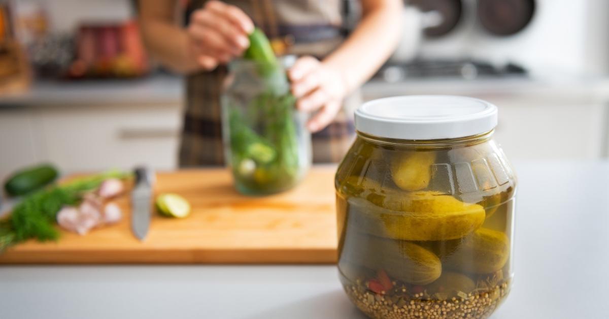 A woman canning cucumbers to make pickles. 