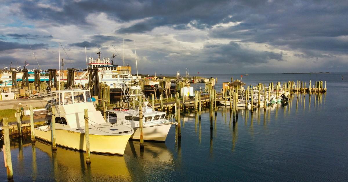Boats are docked at the marina along the coast of Hatteras Island as storm clouds hover in the background 