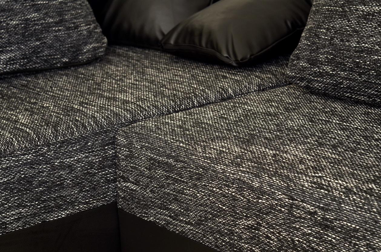 Close up of a couch made of a dark chenille fabric.