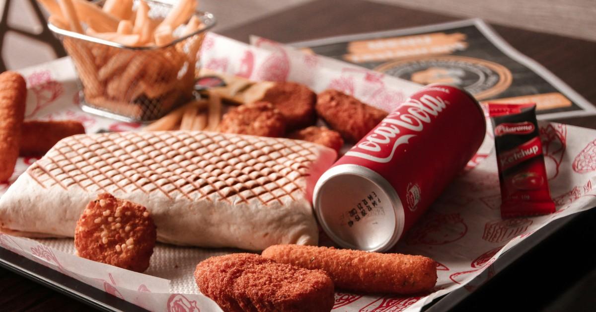 A lunch tray full of processed food including fried items and soda