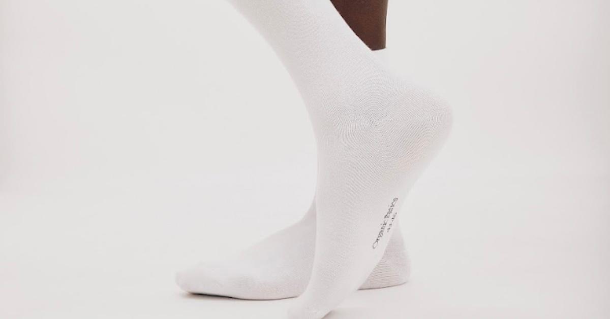 Pair of feet in white Organic Basics high socks