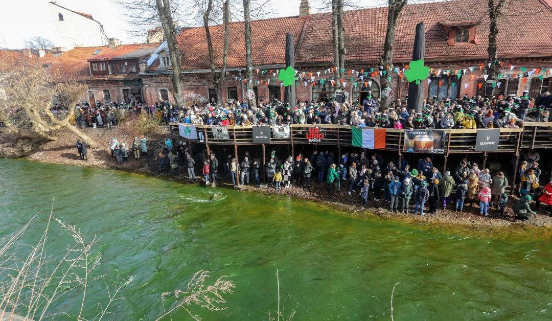 People gather on the banks of the Vilnia river on Saint Patrick's Day in Vilnius, Lithuania