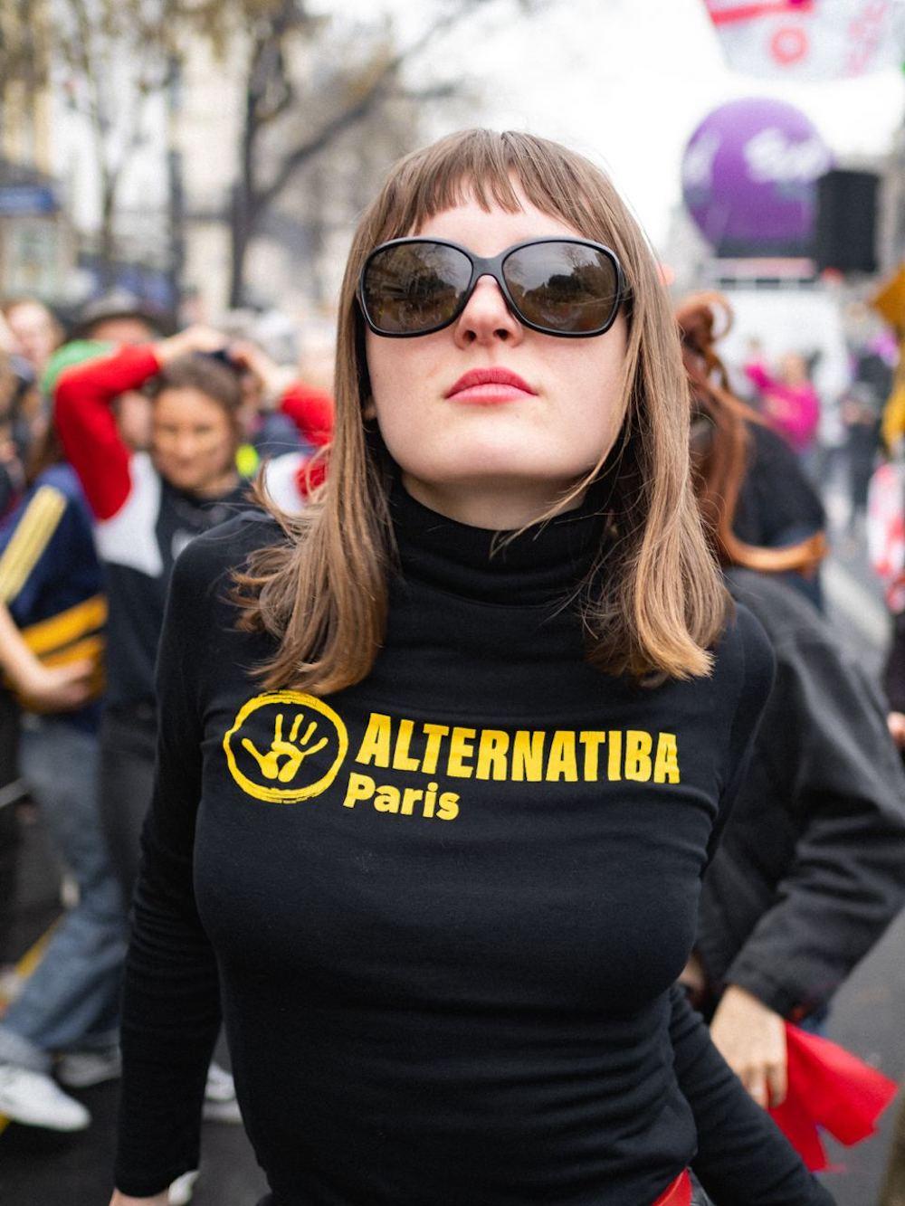 Mathilde Caillard poses in black sunglasses and an Alternatiba Paris turtleneck.