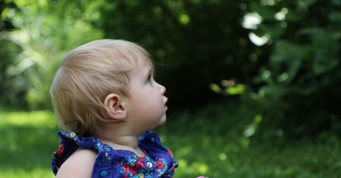 young child sitting in grass