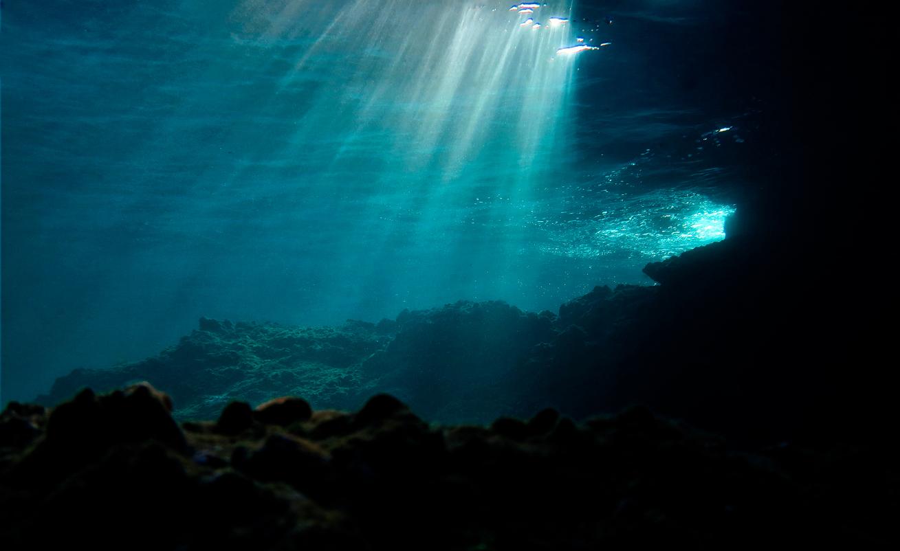 Light shining through dark ocean waters