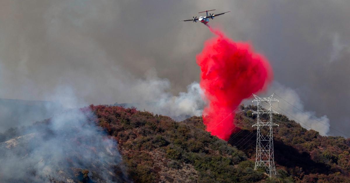 A plane drops hot pink flame retardant on the Palisades fire in Southern California. 