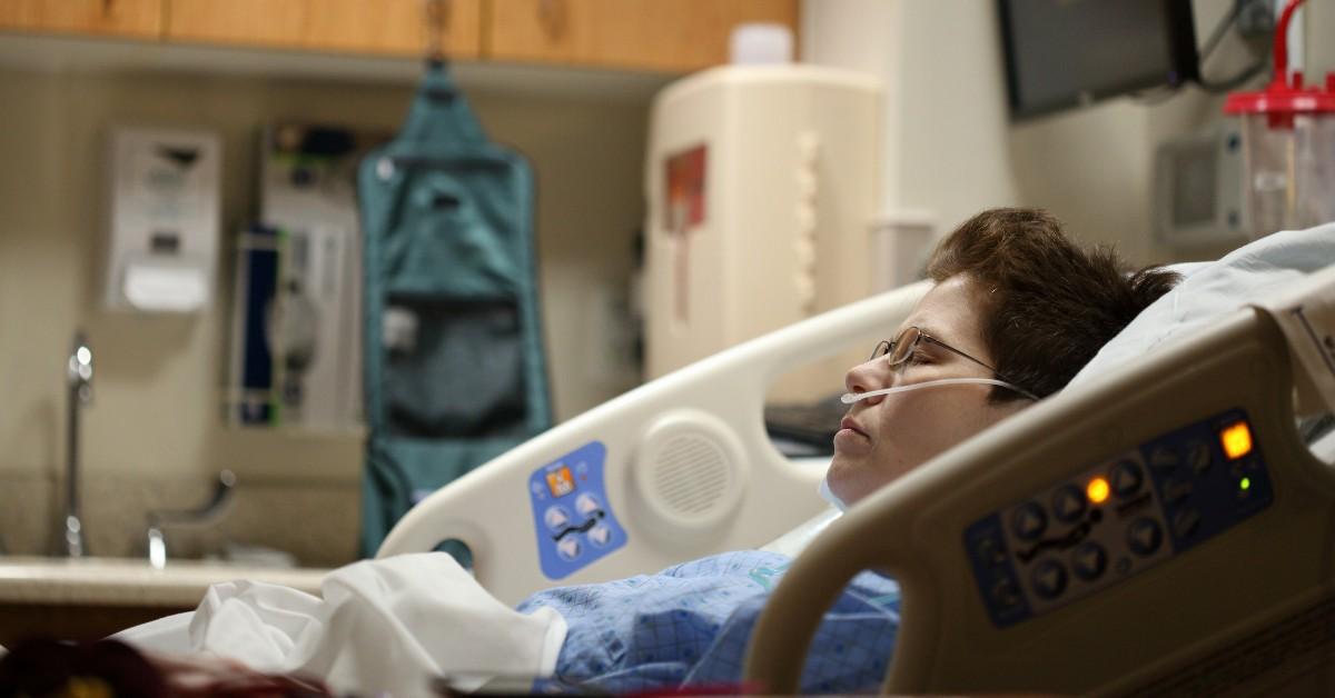 A woman lies in a hospital bed