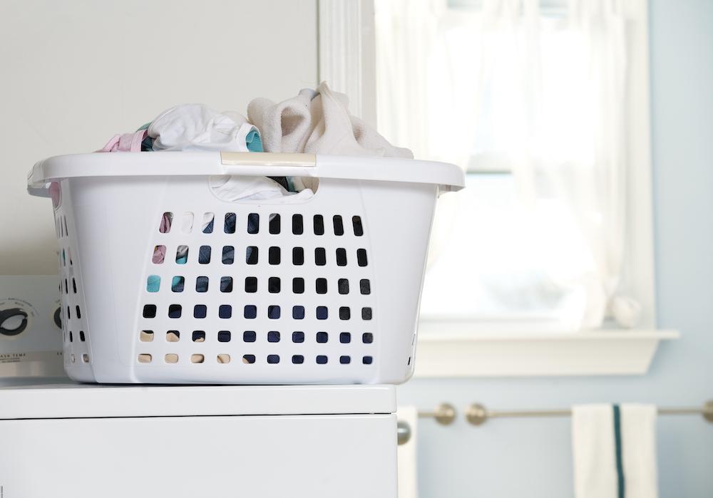 A laundry basket on top of a washing machine.