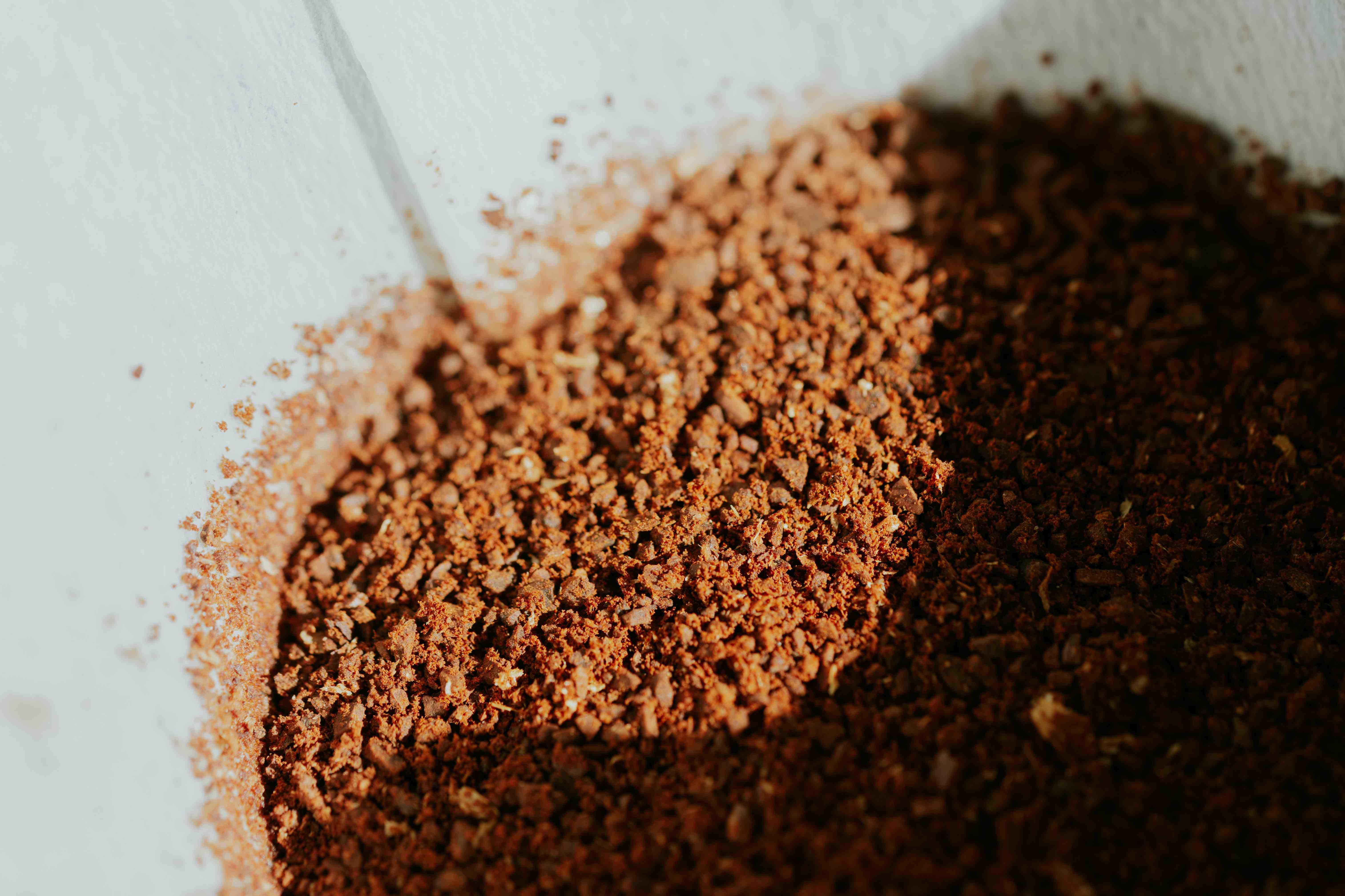 Coffee grounds are pictured atop a white countertop.