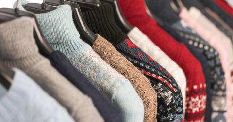 A rack of secondhand sweaters at a thrift store.