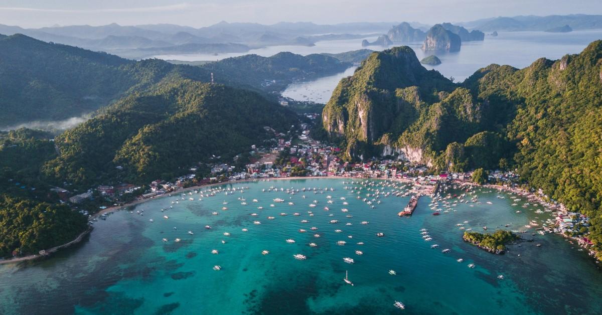 Overhead view of boats sitting in blue water along the coast of the Philippines