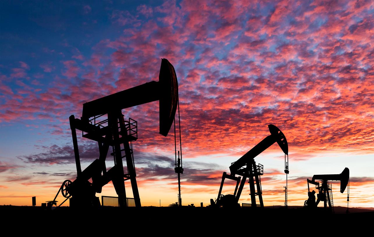 The silhouettes of oil pumpjacks are pictured at sunset.