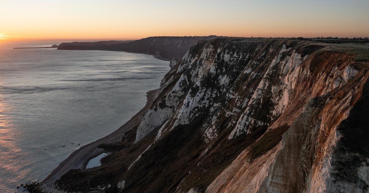 Cliff overlooking an ocean at sunrise