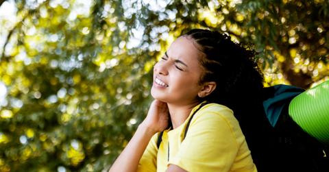 Young woman in yellow shirt rubbing mosquito bites