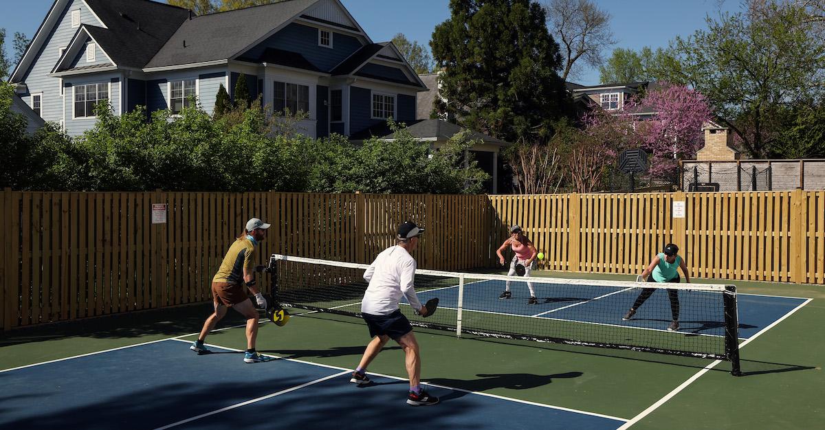People playing pickleball on a standard court.