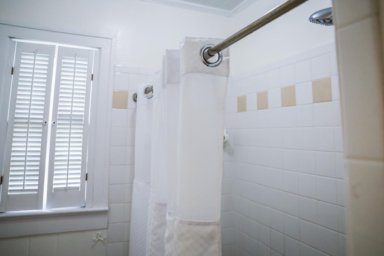 white shower curtain on rod in bathroom