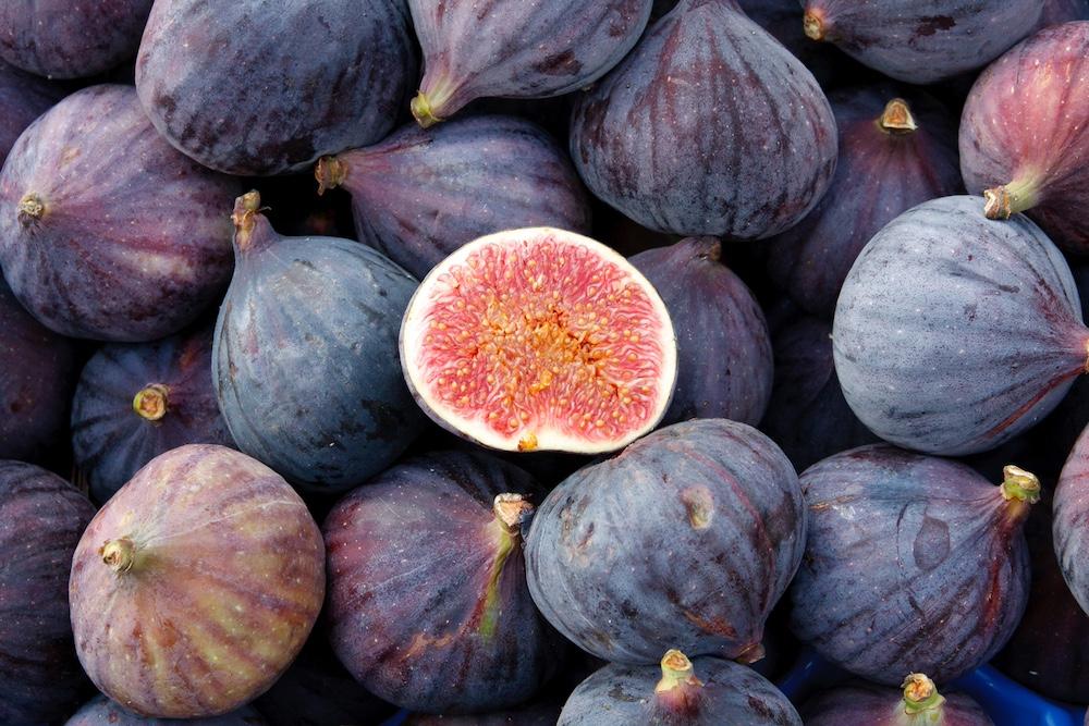 A close up of figs with one cut in half.