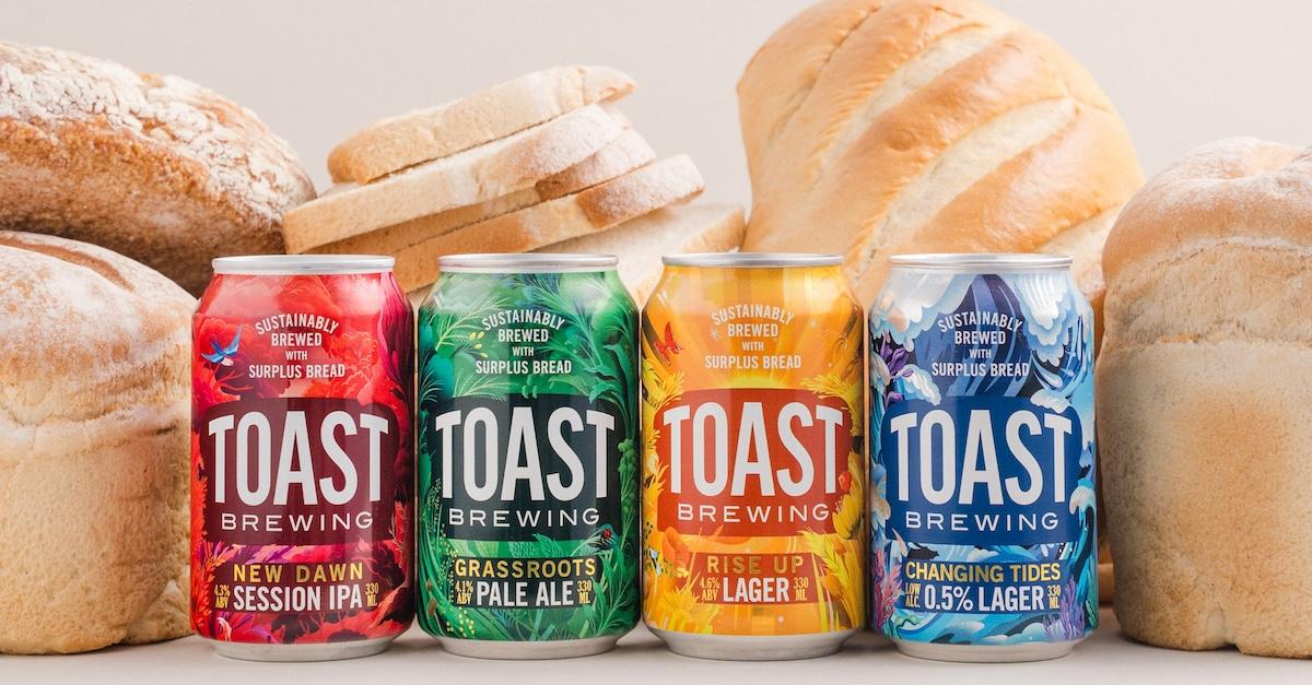 Four cans of Toast Brewing beers alongside loaves of bread