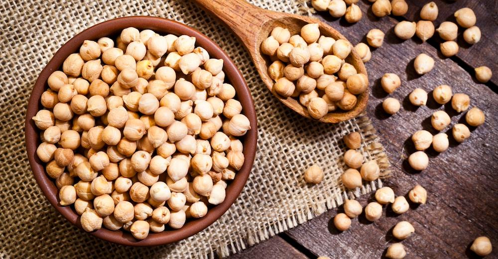 Chickpeas in a wooden bowl and spoon.