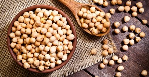 Chickpeas in a wooden bowl and spoon.