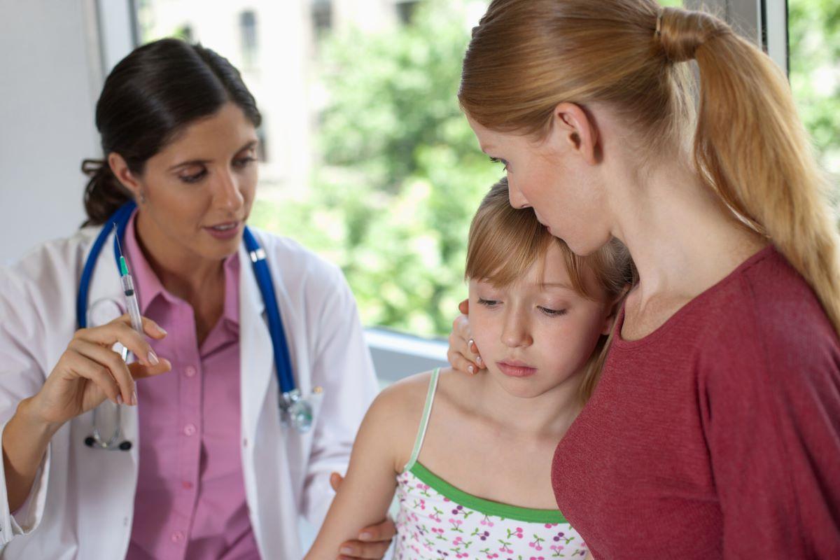 Woman and her daughter at the doctor and about to get a shot