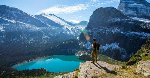 A man standing on an overlook in Glacier National Park. (Cover Image Source: Getty Images | Jordan Siemens)