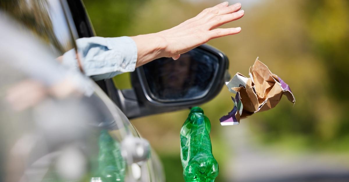 A driver throwing litter out their car window.