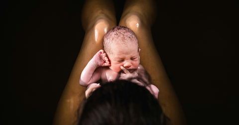 A new parent holds a baby after delivery