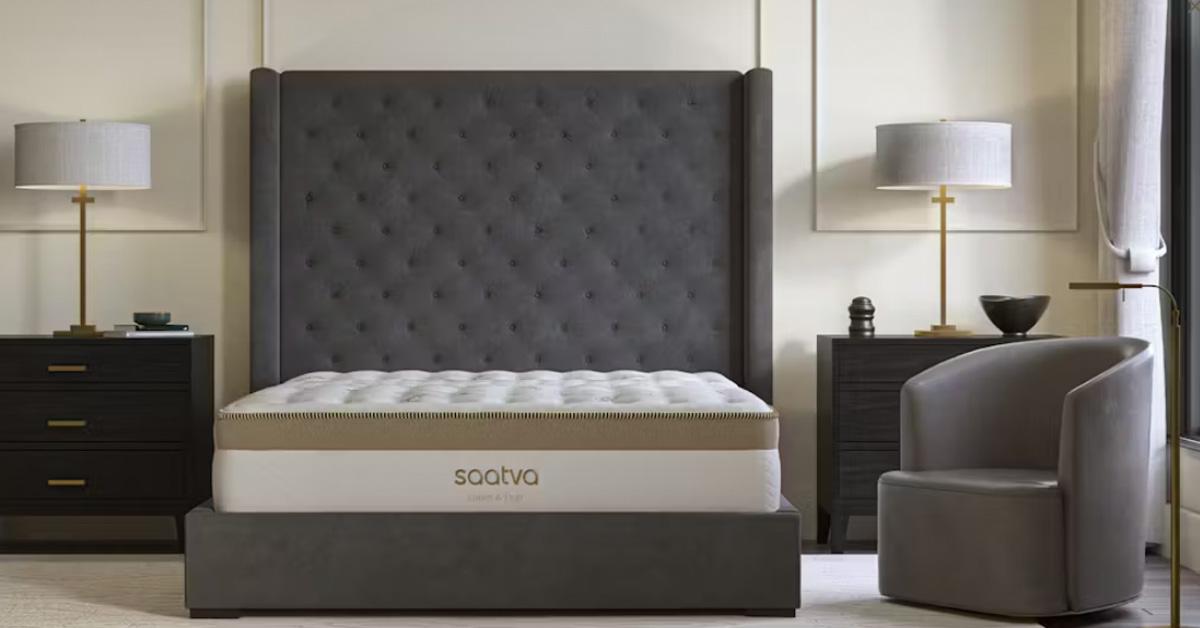 mattress in a grey bed frame in a bedroom with a chair, nightstands, and lamps