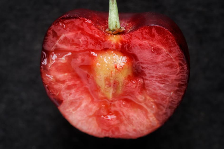 A close-up photo of a cherry cut in half. 