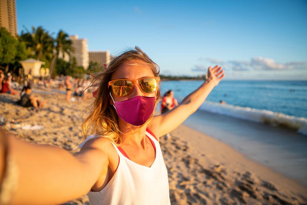 A woman wearing a mask on a beach in Hawaii. 