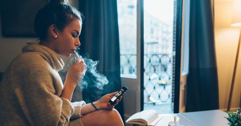 Someone smoking the living room on their phone.