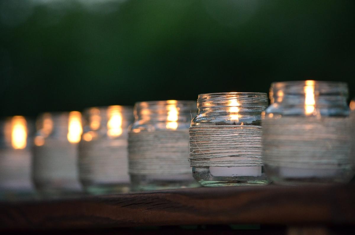 row of glass jars with candles